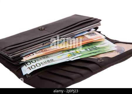 An open wallet full of money in denominations of 50 and 100 euros isolated on a white background close-up Stock Photo