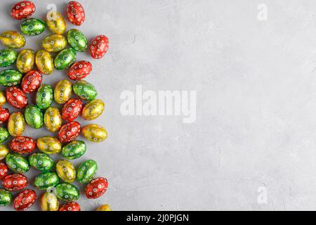Colorful Easter eggs on a grey background with space for text, top view, flat lay. Easter festive background Stock Photo