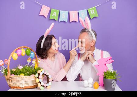 Photo of two peaceful positive people finger touch nose enjoy festive isolated on purple color background Stock Photo