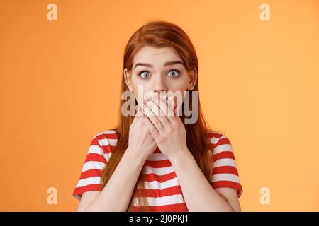 Close-up surprised shocked red girl, stare camera speechless, shut mouth palms astonished very impressed, deeply concerned, real Stock Photo