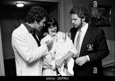 Tom Jones with his grandson Alexander, aged eleven months, son Mark Woodward and daughter-in-law Donna in their London hotel. 3rd September 1983. Stock Photo