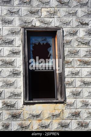 Background image shows a window in Pepper Sauce Alley, ghost town.  Window is faded and weathered wood with broken window pane showing shards of glass Stock Photo