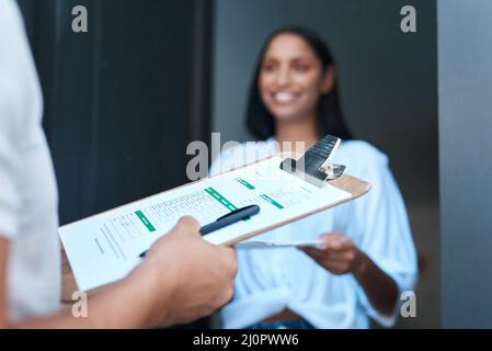 Thank you for the delivery. Shot of a young woman receiving a delivery at home. Stock Photo