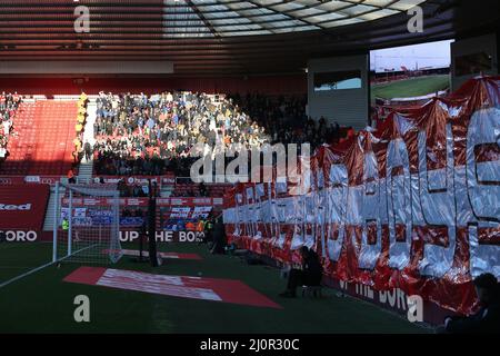 MIDDLESBROUGH, UK. MAR 19TH Middlesbrough's fans hold up a banner in front of the south stand as the Chelsea fans are illuminated by the evening sunshine during the FA Cup match between Middlesbrough and Chelsea at the Riverside Stadium, Middlesbrough on Saturday 19th March 2022. (Credit: Mark Fletcher | MI News) Credit: MI News & Sport /Alamy Live News Stock Photo