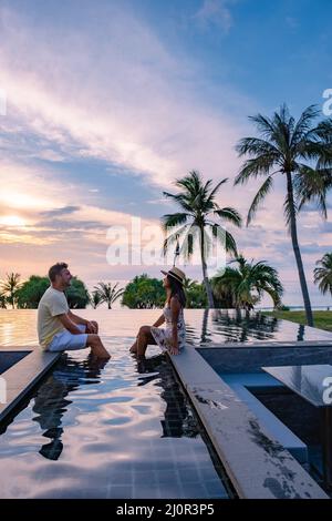couple watching the sunset in an infinity pool on a luxury vacation in ...