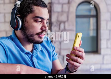 Relaxed male with headphones watching a video at home Stock Photo