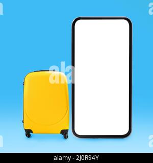 Yellow stylish suitcase and big cell phone screen Stock Photo