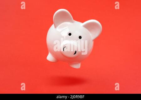Piggy bank levitating over a red background Stock Photo