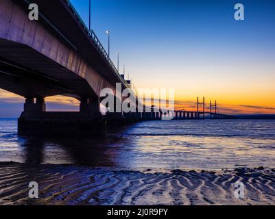Sun setting behind the Prince of Wales Bridge crossing the Severn Estuary between England and Wales UK Stock Photo