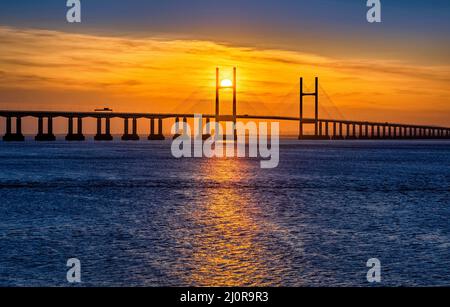 Sun setting behind the Prince of Wales Bridge crossing the Severn Estuary between England and Wales UK Stock Photo