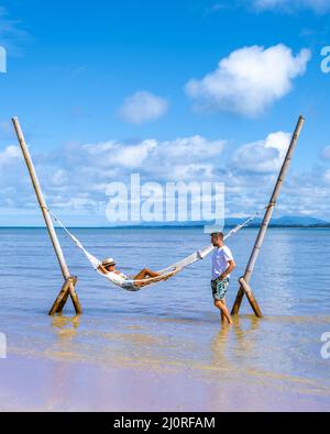 Couple man and woman relaxing in hammock on the beach in Phuket Nai yang beach Thailand Stock Photo