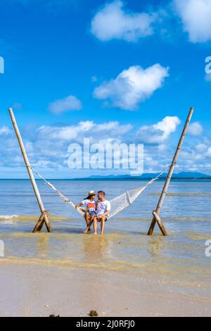 Couple man and woman relaxing in hammock on the beach in Phuket Nai yang beach Thailand Stock Photo
