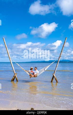 Couple man and woman relaxing in hammock on the beach in Phuket Nai yang beach Thailand Stock Photo