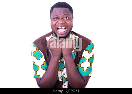 handsome frustrated young man, holding fist near chin and furious strong looking at camera. Stock Photo