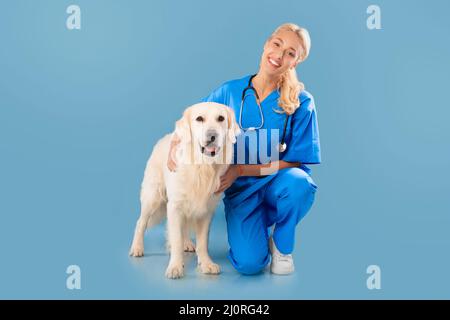 Nurse In Scrubs Uniform And Stethoscope Posing With Dog Stock Photo