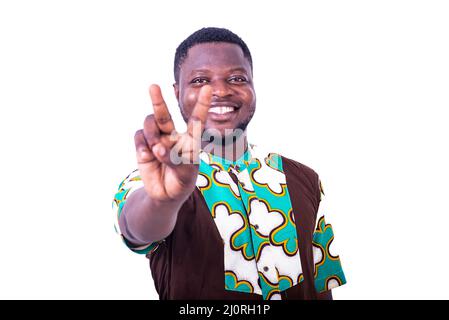 handsome happy young man standing and showing victory gesture with fingers and smiling at camera. Stock Photo