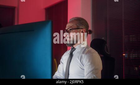 Middle aged long white hair adult office worker or employer doing his job on computer Stock Photo