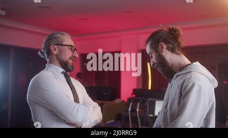 Handsome man in middle aged suit employer is working on a joint project with his young employee Stock Photo