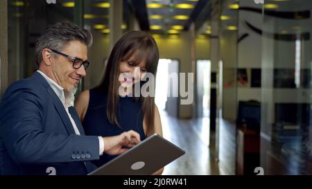 Happy business people working with tablet in office. Businessman and businesswoman teamworking. Stock Photo