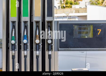 Huelva, Spain - March 10, 2022: Pump nozzles of a petrol pump in service station Stock Photo