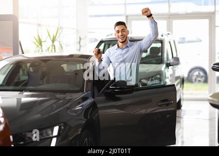 Emotional middle eastern guy buying car of his dream Stock Photo