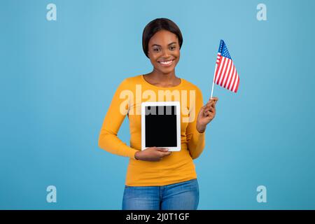 Portrait Of Smiling Black Woman Holding American Flag And Blank Digital Tablet Stock Photo
