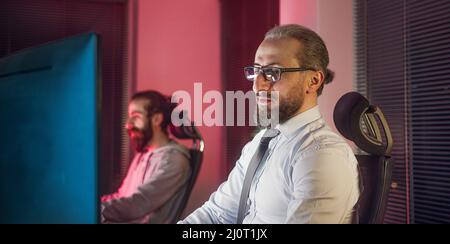 Middle-aged company CEO or boss is training his trainee, trying to help employee with a hand signal Stock Photo