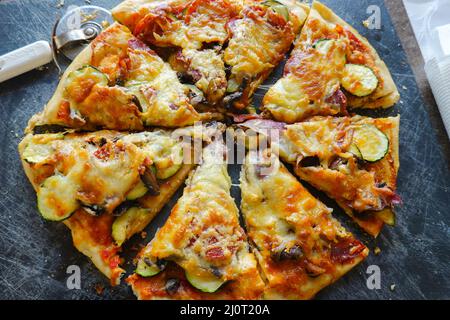 Homemade sliced pizza with a pizza wheel. Stock Photo