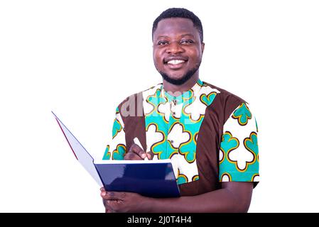 happy young man writing in notebook with pen and smiling at camera. Stock Photo