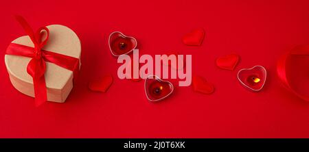 Saint Valentine top view composition with gift box, candles, hearts on red background Stock Photo