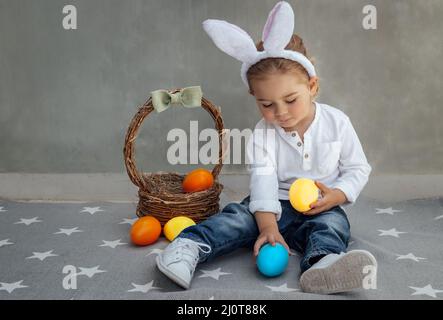 Cute Little Boy Dressed as a Bunny Playing with Decorations. Kid with Colorful Easter Eggs. Happy Easter. Spring Christian Holiday. Stock Photo