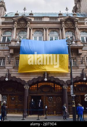 London, UK. 20th March 2022. A large Ukrainian flag hangs outside the London Coliseum theatre in Covent Garden in solidarity with Ukraine, as Russia continues its attack. Credit: Vuk Valcic/Alamy Live News Stock Photo