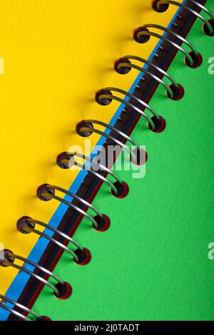 Yellow and green blank pages in a spiral bound notebook Stock Photo
