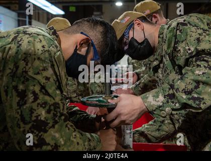 220124-N-OA516-1031  SAN DIEGO (Jan. 24, 2022) – Engineman 3rd Class Eduardo Hernandez, left, and Machinist’s Mate 2nd Class Brandon Eller, Sailors assigned to the San Antonio-class amphibious transport dock ship USS San Diego, repair a valve during the 2022 Self-Sufficiency Challenge at the Southwest Regional Maintenance Center (SWRMC) valve shop. SWRMC provides maintenance support and selective maintenance training to surface ships, submarines, shore activities, and other commands of the U.S. Pacific Fleet. (U.S. Navy photo by Mass Communication Specialist 2nd Class Kevin C. Leitner) Stock Photo