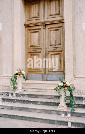 Bouquets of flowers lie on small stone columns on the steps Stock Photo