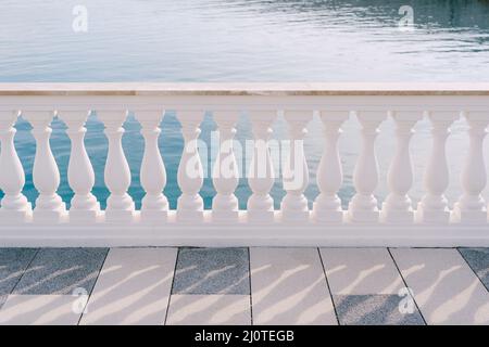 White marble balustrade on a tiled terrace by the sea Stock Photo