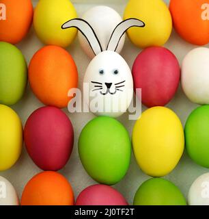 Funny bunny among colorful eggs. Holiday card. Easter background Stock Photo