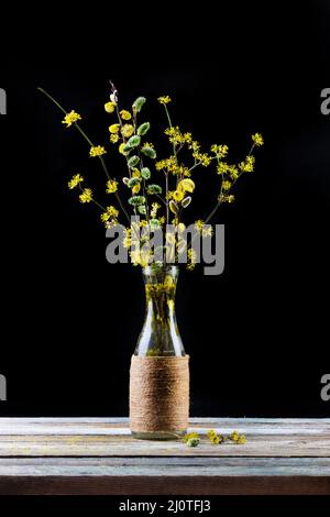 Bouquet of flowering branches of willow and dogwood in a vase on the table on a black background Stock Photo