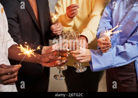 Close up of colleague lighting sparklers while celebrating Birthday in office Stock Photo