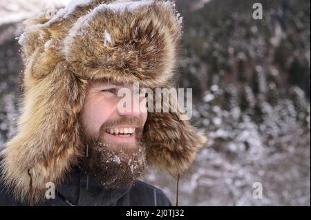 A Man In A Fur Winter Hat With Ear Flaps Stock Photo, Picture and Royalty  Free Image. Image 17543420.