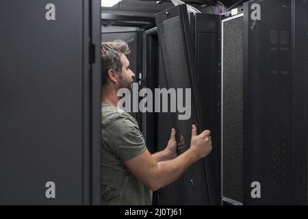 IT engineer working In the server room or data center The technician puts in a rack a new server of corporate business mainframe Stock Photo
