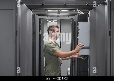 IT engineer working In the server room or data center The technician puts in a rack a new server of corporate business mainframe Stock Photo