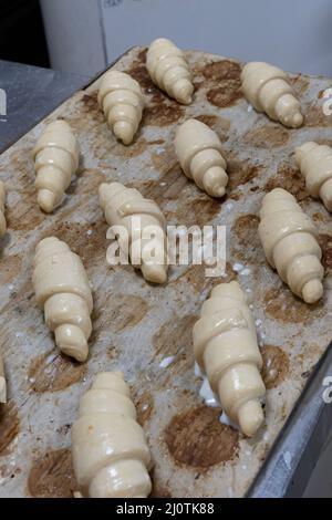 Artisan baker and pastry chef. Chef baker preparing croissants in a bakery Stock Photo