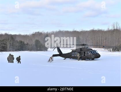 GRAYLING, Mich. – U.S. Army Soldiers from Bravo Company 1-147 Aviation Battalion in Grand Ledge, MI fly in to pick up Fire Support Teams from Delta Battery, 1st Battalion 120th Field Artillery Regiment, Wisconsin National Guard to move them from an Observation Post after a day of calling for artillery live fire exercises during Northern Strike 22-1 also known as “Winter Strike” on Jan. 26, 2022. “Winter Strike” is held annually in northern Michigan during the coldest part of the year. Snow, high winds, and single-digit temperatures are commonplace at the National All-Domain Warfighting Center Stock Photo