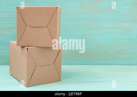 Stack of cardboard boxes on blue wooden background Stock Photo