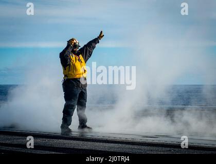 Aviation Boatswain’s Mate (Handling) Jose Mercado directs an aircraft to the launch zone on the flight deck of the aircraft carrier USS George H. W. Bush (CVN 77). GHWB provides the national command authority flexible, tailorable war fighting capability through the carrier strike group that maintains maritime stability and security in order to ensure access, deter aggression and defend U.S., allied and partner interests. (U.S. Navy photo by Mass Communication Specialist 3rd Class Brandon Roberson) Stock Photo