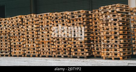 Stacks of wooden pallets in warehouse outdoor storage for industrial transportation. Stock Photo