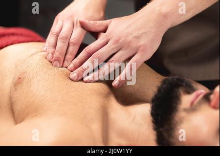 https://l450v.alamy.com/450v/2j0w1yy/a-professional-therapist-massages-the-pectoral-muscle-of-an-athlete-to-a-man-in-a-professional-massage-salon-the-concept-of-pro-2j0w1yy.jpg