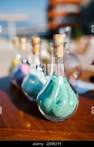 Glass bottles with colored sand are on the table Stock Photo