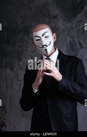 Midsection of a businessman wearing the mask of anonymous / Guy Fawkes Stock Photo